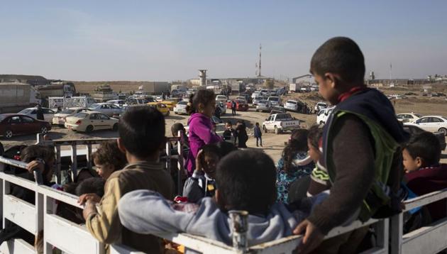 Children wait on the back of a pick up truck outside the Khazer checkpoint on the road to Mosul, Tuesday Feb. 7, 2017. T (AP Photo) Children wait on the back of a pick up truck outside the Khazer checkpoint on the road to Mosul, Tuesday Feb. 7, 2017. T (AP Photo)