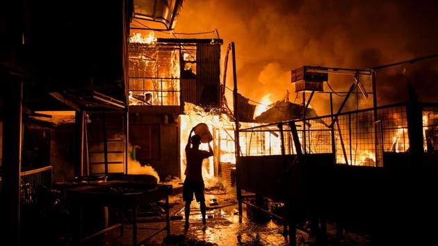 A resident pours water on a fire as it destroys hundreds of houses at an informal settlers community in Delpan, Tondo, Manila on February 7. (AFP Photo) A resident pours water on a fire as it destroys hundreds of houses at an informal settlers community in Delpan, Tondo, Manila on February 7. (AFP Photo)