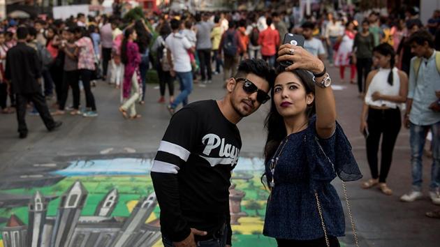 Youngsters take a selfie with a 3D artwork in the background at Rampart Row. (Satish Bate/HT PHOTO) 