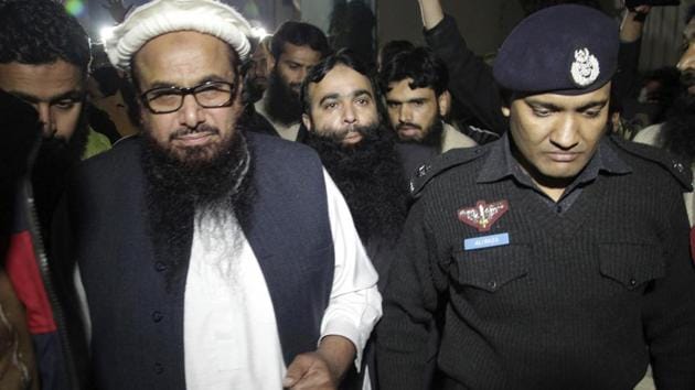 A Pakistani police officer escorts Lashkar-e-Taiba founder Hafiz Saeed in Lahore on January 30, 2017 after he was placed under house arrest. (AP) A Pakistani police officer escorts Lashkar-e-Taiba founder Hafiz Saeed in Lahore on January 30, 2017 after he was placed under house arrest. (AP)
