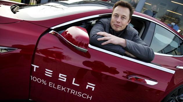 Elon Musk, co-founder and CEO of Tesla, poses with a model of the brand during a visit to Amsterdam.