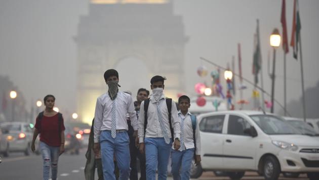 School students covers their face with a handkerchief to avoid thick smog at Janpath Market in New Delhi on November 4, 2016. Delhi ranks fourth for the average annual particulate matter pollution in 2016.(Raj K Raj/HT File Photo)