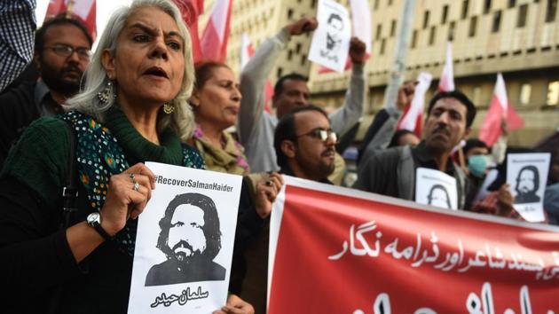 Activists hold images of bloggers who went missing during a protest in Peshawar.(AFP)
