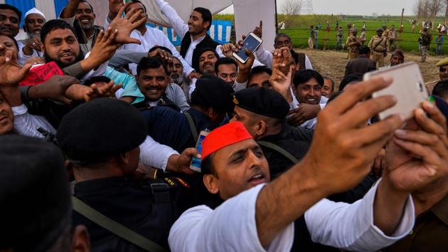 Uttar Pradesh state Chief Minister Akhilesh Yadav (C) takes a selfie during a public rally at Sardhana in Meerut. March 11 is the day of reckoning for all parties, when election results will be declared. (CHANDAN KHANNA / AFP)