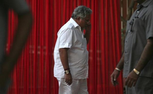 Kingfisher Airlines Chairman Vijay Mallya speaks on a mobile phone amid his security personnel on guard during a meeting with the debt-laden airline's pilots in New Delhi March 15, 2012. Kingfisher Airlines Chairman Vijay Mallya speaks on a mobile phone amid his security personnel on guard during a meeting with the debt-laden airline's pilots in New Delhi March 15, 2012.