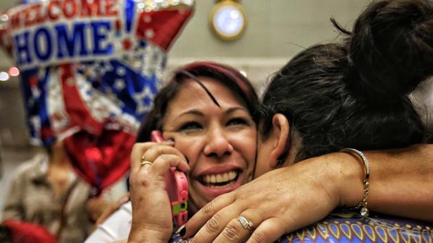 Cuban health worker Veidy Diaz, center, is greeted by family and friends as she talks on the phone after finally leaving the immigration and customs section of Miami International Airport. (AP Photo) Cuban health worker Veidy Diaz, center, is greeted by family and friends as she talks on the phone after finally leaving the immigration and customs section of Miami International Airport. (AP Photo)