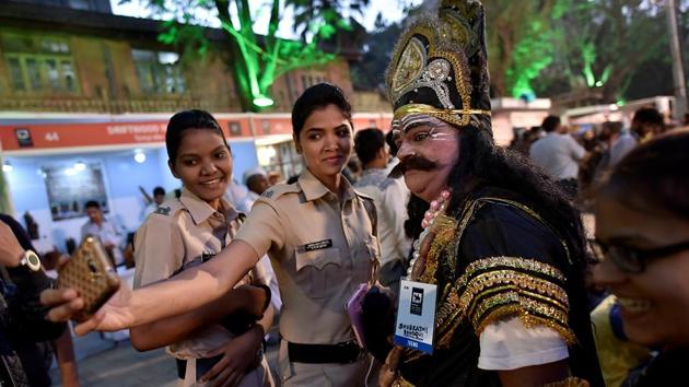Policewomen take a photograph with a man dressed as a mythological figure. (Arijit Sen/HT PHOTO) 