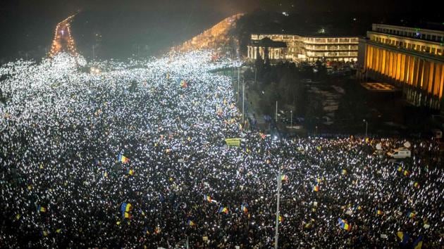 Demonstrators turn on the lights of their mobile phones as they protest against the Romanian government's contentious decree decriminalising certain corruption offences, in front of the government headquarters at the Victoriei square in Bucharest. (ANDREI PUNGOVSCHI / AFP) Demonstrators turn on the lights of their mobile phones as they protest against the Romanian government's contentious decree decriminalising certain corruption offences, in front of the government headquarters at the Victoriei square in Bucharest. (ANDREI PUNGOVSCHI / AFP)