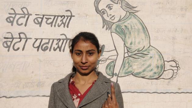 A female voter poses on the backdrop of a wall painting, promoting PM Narendra Modi’s Beti bachao, Beti padhao” campaign, after casting her vote in Jewar constituency in Greater Noida on Saturday. (Sunil Ghosh / HT photo )