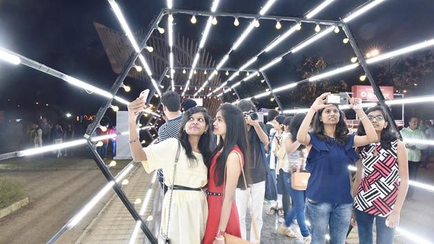 Youngsters stop by to admire an artwork of light. (Anshuman Poyrekar/HT PHOTO) 