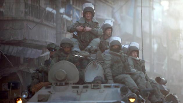 Russian soldiers, on armoured vehicles, patrol a street in Aleppo. Iran and Russia are closely cooperating in Syria and provide political, financial and military backing to the regime of President Bashar al-Assad.(Reuters file)