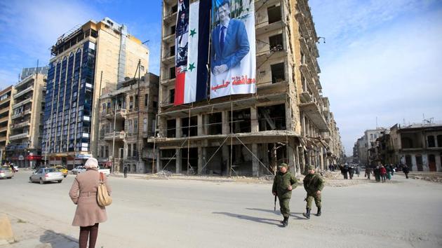 Russian soldiers and civilians walk along a street in Aleppo, Syria, on January 30, 2017. (Reuters) Russian soldiers and civilians walk along a street in Aleppo, Syria, on January 30, 2017. (Reuters)