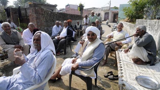 Senior citizens discuss the polls after casting their votes at Parsaul of Greater Noida on Saturday. (Sunil Gosh / HT photo )