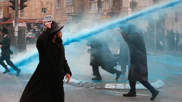 Israeli police spray water at ultra-Orthodox Jews during a protest against Israeli army conscription, in Jerusalem. Many ultra-Orthodox oppose military service for their young men because they believe it exposes them to influences and temptations not found in the insular world of prayer and religious study. (AHMAD GHARABLI / AFP) Israeli police spray water at ultra-Orthodox Jews during a protest against Israeli army conscription, in Jerusalem. Many ultra-Orthodox oppose military service for their young men because they believe it exposes them to influences and temptations not found in the insular world of prayer and religious study. (AHMAD GHARABLI / AFP)