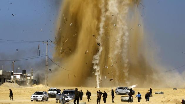 Palestinians run for cover as smoke rises following an Israeli air strike on a Hamas post, in northern Gaza Strip on February 6, 2017. Israel struck a number of Hamas positions in Gaza after a "projectile" fired from the Palestinian enclave crashed in a border area, the Israeli army said. (MOHAMMED ABED / AFP) Palestinians run for cover as smoke rises following an Israeli air strike on a Hamas post, in northern Gaza Strip on February 6, 2017. Israel struck a number of Hamas positions in Gaza after a "projectile" fired from the Palestinian enclave crashed in a border area, the Israeli army said. (MOHAMMED ABED / AFP)