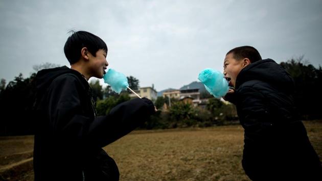 Children enjoy a candy floss during the ‘beat the Buddha’ celebrations in Yuxi village. (AFP Photo) Children enjoy a candy floss during the ‘beat the Buddha’ celebrations in Yuxi village. (AFP Photo)
