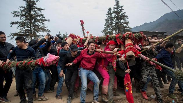 In preparation for the event, villagers wrap the centuries-old Buddha (a rock) in red cloth and rinse it with water, before tightly tying it to a wooden palanquin. (AFP Photo) In preparation for the event, villagers wrap the centuries-old Buddha (a rock) in red cloth and rinse it with water, before tightly tying it to a wooden palanquin. (AFP Photo)