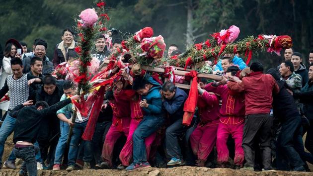 Four men, who had been on a strict vegetarian diet for three days, carry the palanquin across a nearby river, while another team of more than a dozen try to stop them by blocking them with freshly hewn bamboo sticks. (AFP Photo) Four men, who had been on a strict vegetarian diet for three days, carry the palanquin across a nearby river, while another team of more than a dozen try to stop them by blocking them with freshly hewn bamboo sticks. (AFP Photo)