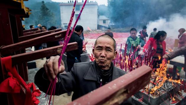 Villagers pray, burn incense during the celebrations in Yuxi village. (AFP Photo) Villagers pray, burn incense during the celebrations in Yuxi village. (AFP Photo)
