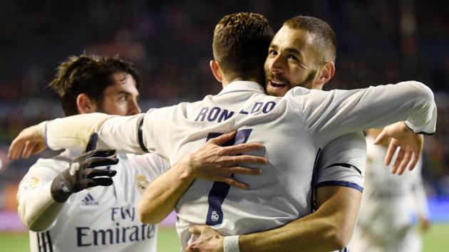 Real Madrid's Cristiano Ronaldo (C) is congratulated by teammates after scoring his team's first goal against Osasuna. (AFP) Real Madrid's Cristiano Ronaldo (C) is congratulated by teammates after scoring his team's first goal against Osasuna. (AFP)