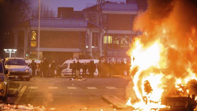 French police officers face protestors as a car burns in Bobigny, outside Paris, Saturday, Feb. 11.(AP Photo)