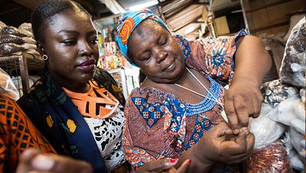 Essie Bartels buys spices from her seller Aisha Ibrahim at the Makola market in Accra.(AFP)