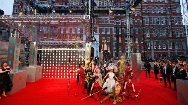 Cast members of Cirque de Soleil perform on the red carpet. (REUTERS)