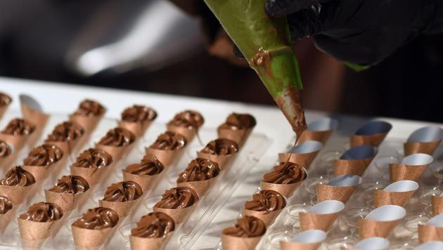 An exhibitor fills cups with chocolate on February 10, 2017 on the opening day of the Brussels Chocolate Fair in the Belgian capital, Brussels. (EMMANUEL DUNAND / AFP)