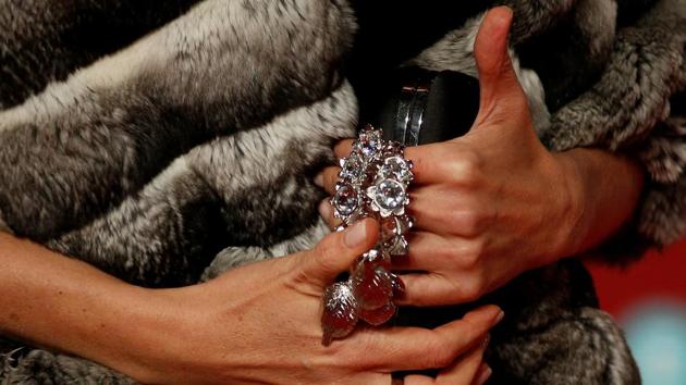 A guest wearing large jewellery arrives for the award night. (REUTERS)