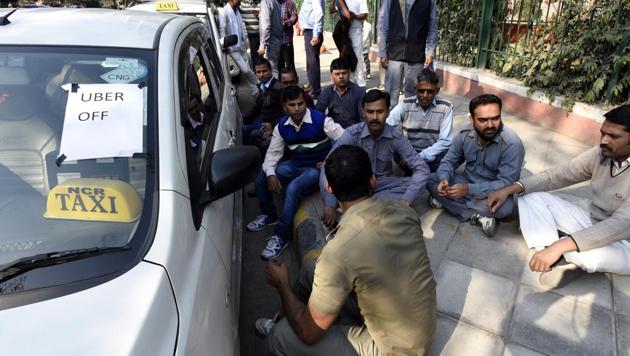 Ola and Uber taxi drivers sit near their cars during the strike against withdrawal of incentives by the app-based cab aggregators, in New Delhi.(Sonu Mehta/HT PHOTO)