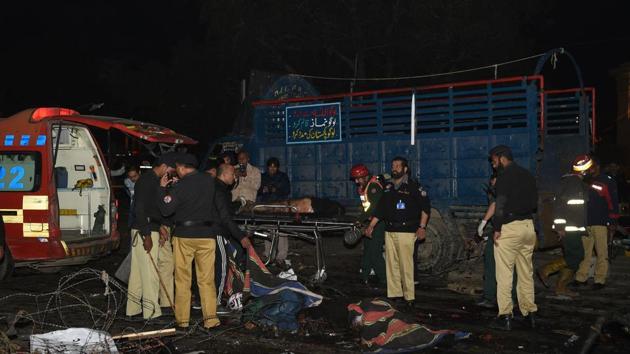 Pakistani policemen and volunteers move the bodies of victims at the site of a bomb explosion in Lahore on February 13, 2017.(AFP Photo)