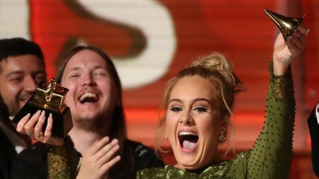 Adele breaks the Grammy for Record of the Year for Hello after having it presented to her at the 59th Annual Grammy Awards in Los Angeles on Monday. (REUTERS) Adele breaks the Grammy for Record of the Year for Hello after having it presented to her at the 59th Annual Grammy Awards in Los Angeles on Monday. (REUTERS)