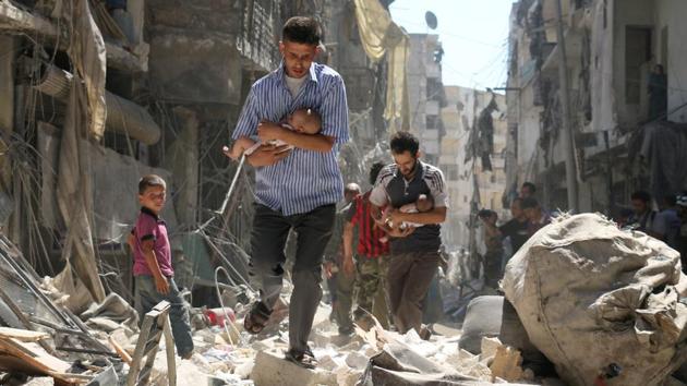 Spot news, second prize: Syrian men carrying babies make their way through the rubble of destroyed buildings following a reported airstrike on the rebel-held Salihin neighborhood of Aleppo. (Ameer Alhalbi )