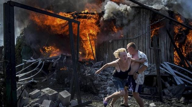 Long-Term Projects, first prize stories: Civilians escape from a fire at a house destroyed by an air attack in the Luhanskaya village. (Valery Melnikov / AP Photo)