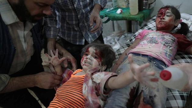 Second prize in the Spot News category: A Syrian girl cries out as a wounded child lies next to her at a makeshift hospital on in September, 2016. (Abd Doumany)
