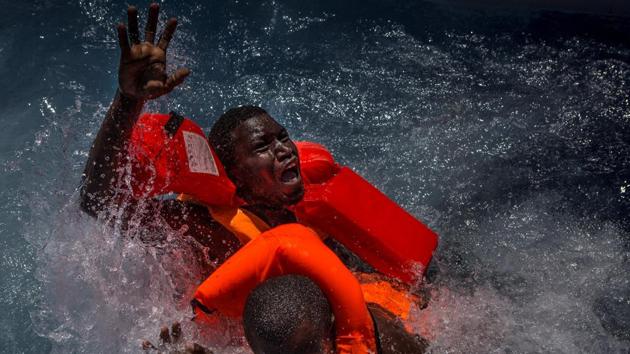 Spot news, second prize: Two men panic and struggle in water during their rescue. Their rubber boat was in distress and deflating quickly on one side, tipping many migrants in the water. They were quickly reached by rescue swimmers and brought to safety. (Mathieu Willcocks)
