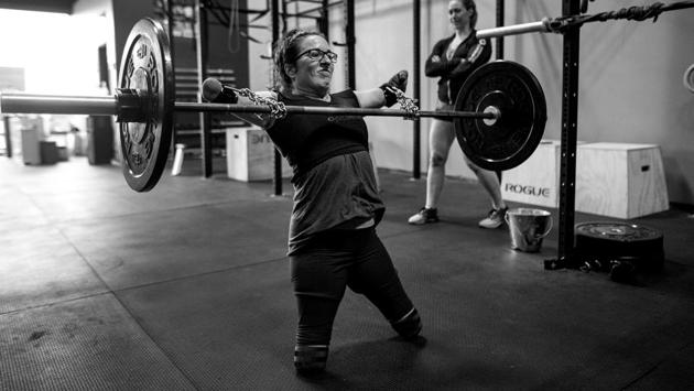 Sports, third prize stories: With the aid of chains purchased at the hardware store and deadlift straps, Lindsay performs cleans under the watchful eye of her coach Jenny Jeffries. (Darren Calabrese )