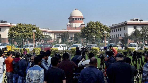 People gather outside the Supreme Court building in New Delhi on Tuesday.(PTI Photo)