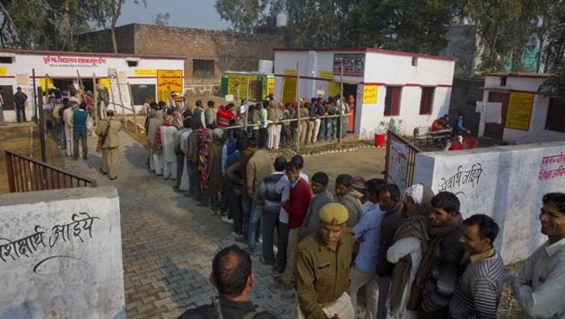 Voters standing in a queue to cast their votes at a polling station in Shahabajpur Dora village in Uttar Pradesh on Feb 15.(AP Photo)