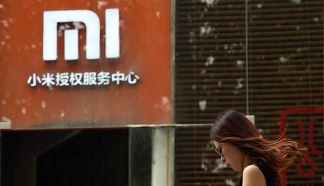 A woman walks past a Xiaomi logo outside a Xiaomi shop in Beijing. (AFP) A woman walks past a Xiaomi logo outside a Xiaomi shop in Beijing. (AFP)