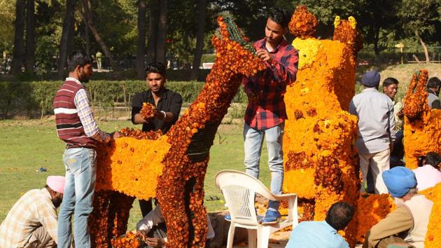 Workers decorating the garden with flowers ahead of the festival in Chandigarh on Thursday. (Sanjeev Sharma/HT Photo) 