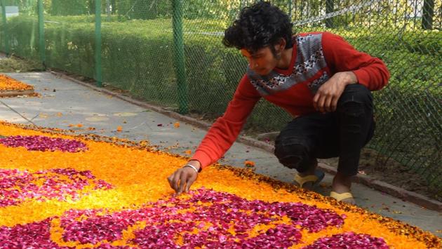 A man preparing a rangoli with flowers at Rose Garden in Chandigarh on Friday. (Sanjeev Sharma/HT Photo) 