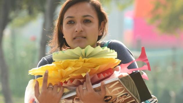 A girl carrying decorating material at Rose Garden in Chandigarh on Friday. (Sanjeev Sharma/HT Photo) 