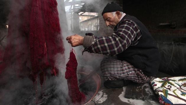 A worker dyes threads at a dyeing center in Srinagar. (Waseem Andrabi /HT PHOTO )