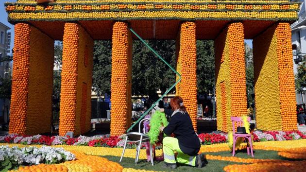 A worker checks a sculpture which depicts the musical comedy "Cabaret". Up to 145 tons of citrus fruit (oranges and lemons) from Spain, 500,000 elastics for attaching the fruit to different decorations, 120 liters of paint, 15 tons of metal and hundreds of meters of metal netting to cover the steel frames will be used this year for festival. (Eric Gaillard / REUTERS)