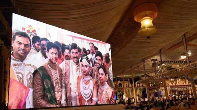 Controversial mining tycoon, Gali Janardhan Reddy, (C) is seen on a big screen as he poses with his daughter Bramhani (2R) and son-in-law, Rajeev Reddy (2L) during their wedding at the Bangalore Palace Grounds in Bangalore. Reddy took over a royal palace and flown in Brazilian dancers at a reported cost of 75 million dollars to celebrate his daughter's wedding.(AFP)