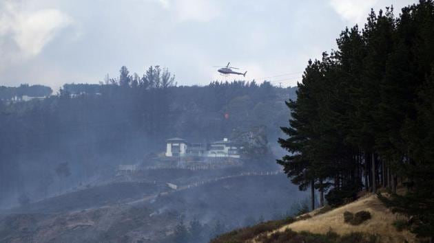 A helicopter dousing the fire in Christchurch early on February 16, 2017. (Oliver WATSON / AFP)