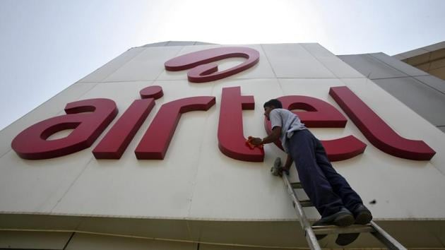 A file photo of a worker cleaning a logo of Bharti Airtel at its zonal office building in the northern Indian city of Chandigarh.(REUTERS)