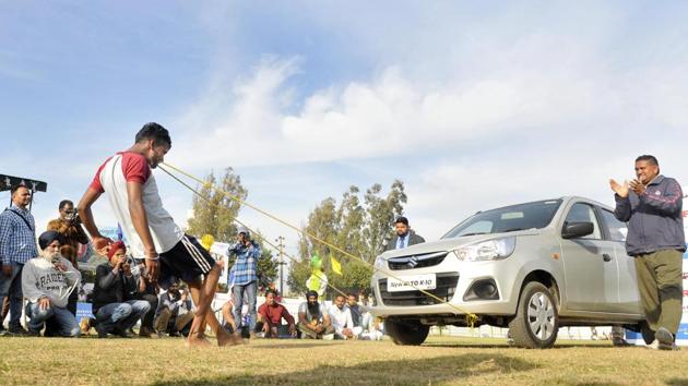 A man pulls a car with his teeth on the inaugural day of Kila Raipur Rural Sports Festival at village Kila Raipur in Ludhiana on Friday. (Gurminder Singh/HT Photo)