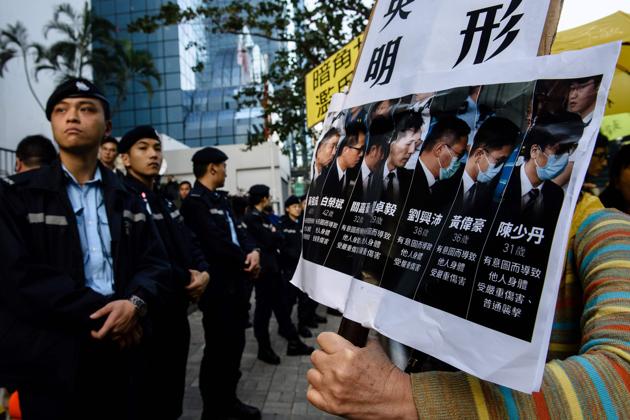 Pro-democracy supporters chant slogans and hold placards in protest against the seven police officers (pictured in placard on right), who were found guilty of assaulting activist Ken Tsang during the 2014 pro-democracy protests, outside the District Court in Hong Kong on February 17, 2017. (AFP) Pro-democracy supporters chant slogans and hold placards in protest against the seven police officers (pictured in placard on right), who were found guilty of assaulting activist Ken Tsang during the 2014 pro-democracy protests, outside the District Court in Hong Kong on February 17, 2017. (AFP)
